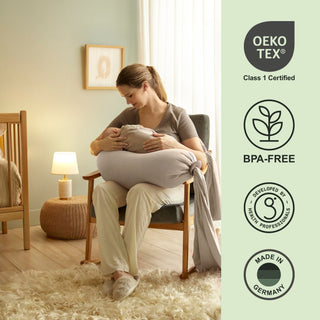 Woman holding a large pillow in a cozy room with Oeko-Tex and BPA-Free certification icons on the right bbhugme pregnancy pillow